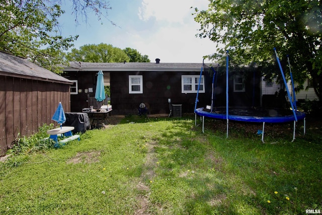 109 N 19th St, Pekin, IL 61554 - back of property with a trampoline, a lawn, and central air condition unit