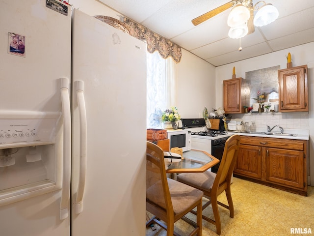 1218 N Sheridan Rd, Peoria, IL 61606 - kitchen with white appliances, a sink, brown cabinetry, ceiling fan, and a desk