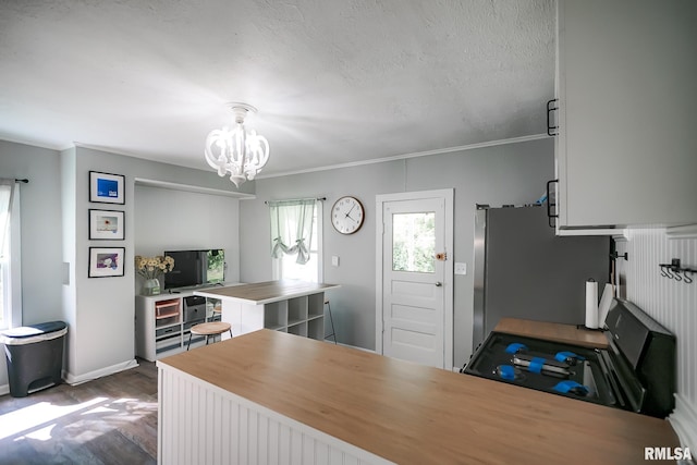 kitchen featuring a chandelier, freestanding refrigerator, dark wood finished floors, gas stove, and baseboards