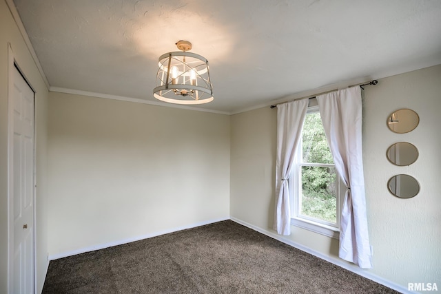 unfurnished room with dark colored carpet, a chandelier, baseboards, and ornamental molding