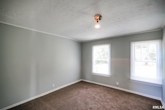 spare room with baseboards, dark carpet, ornamental molding, and a textured ceiling