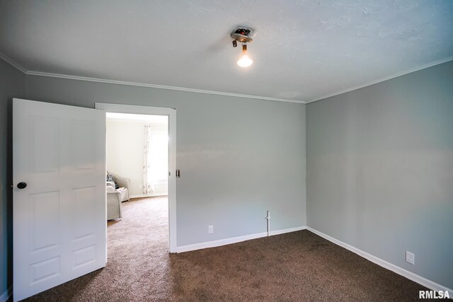 carpeted empty room featuring crown molding and baseboards