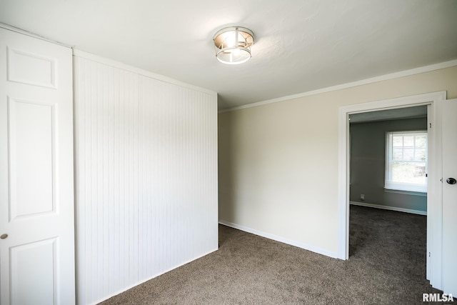 unfurnished room with carpet flooring, crown molding, and baseboards