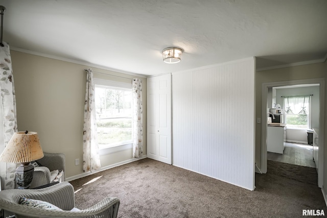 sitting room with plenty of natural light, ornamental molding, carpet, and baseboards