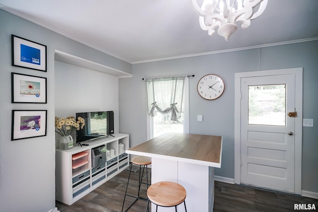 kitchen with a chandelier, plenty of natural light, dark wood-style floors, a kitchen bar, and ornamental molding