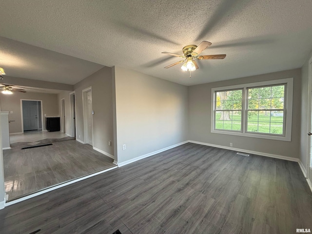 528 Cass St, East Peoria, IL 61611 - unfurnished living room featuring ceiling fan, baseboards, dark wood-type flooring, and a textured ceiling
