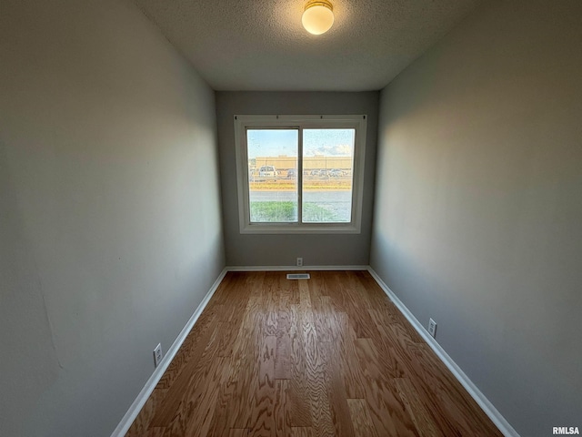 528 Cass St, East Peoria, IL 61611 - unfurnished room with wood finished floors, a textured ceiling, and baseboards