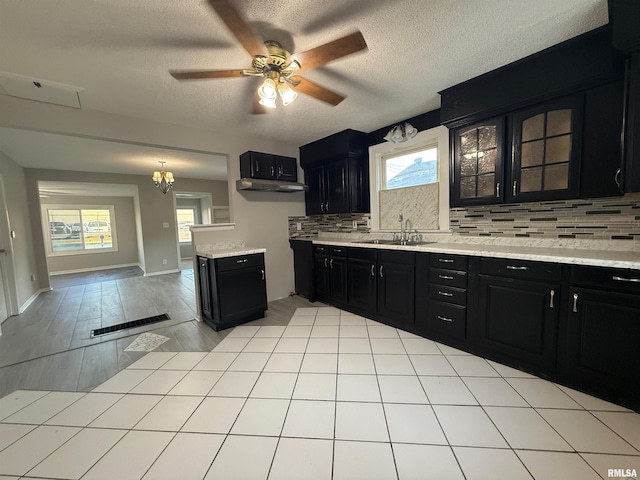 528 Cass St, East Peoria, IL 61611 - kitchen with dark cabinets, a sink, backsplash, light countertops, and ceiling fan