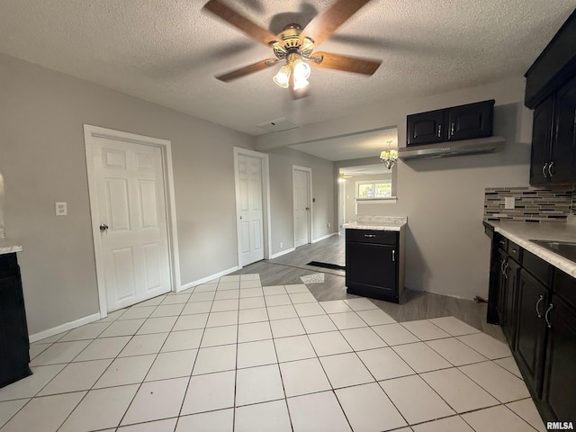 528 Cass St, East Peoria, IL 61611 - kitchen with dark cabinets, light countertops, a ceiling fan, and a textured ceiling