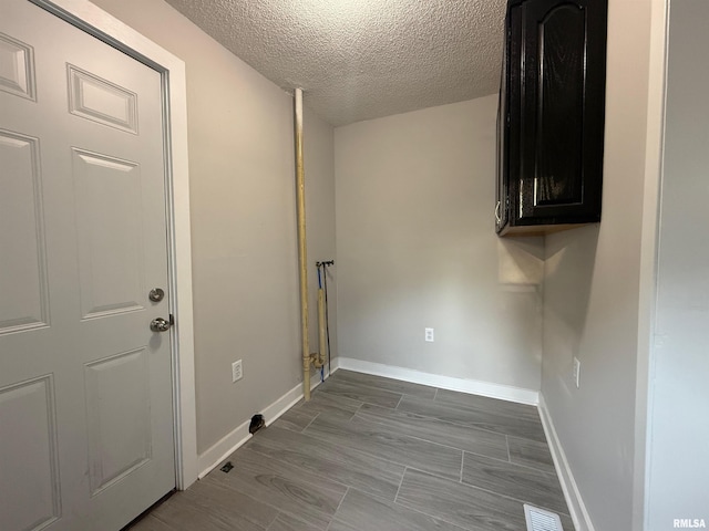 528 Cass St, East Peoria, IL 61611 - laundry room with cabinet space, a textured ceiling, and baseboards