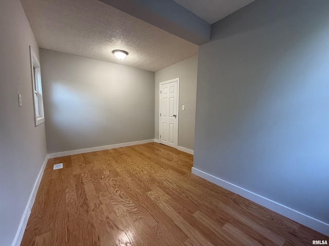 528 Cass St, East Peoria, IL 61611 - empty room with wood finished floors, baseboards, and a textured ceiling
