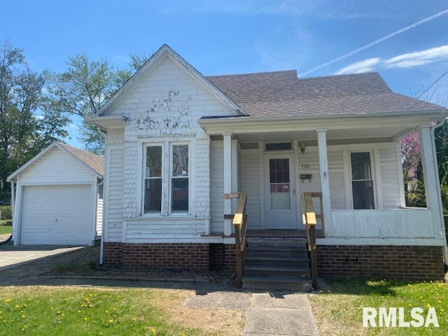 731 S Johnson St, Macomb, IL 61455 - bungalow-style home with covered porch, an outbuilding, concrete driveway, and a shingled roof