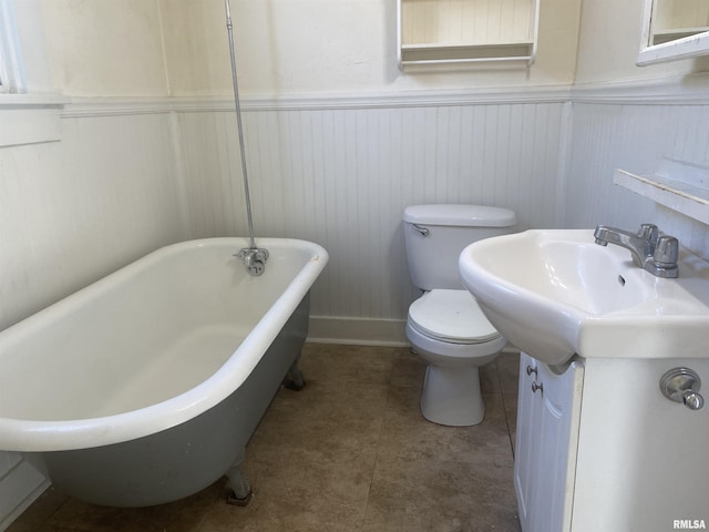 731 S Johnson St, Macomb, IL 61455 - bathroom with toilet, a freestanding bath, wainscoting, vanity, and baseboards