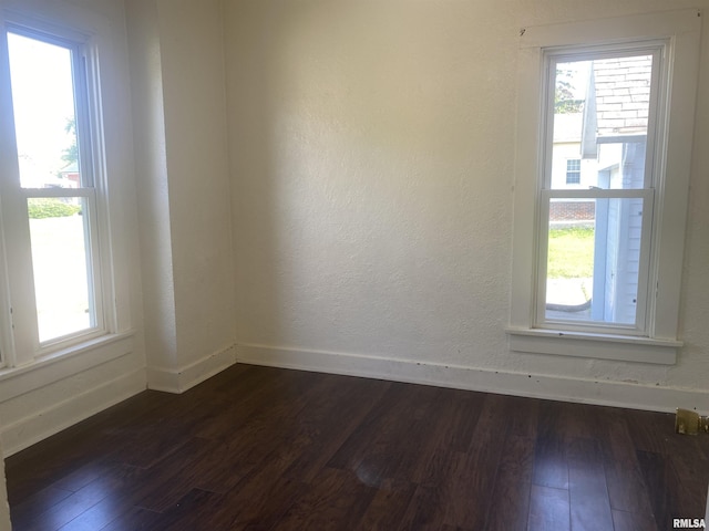731 S Johnson St, Macomb, IL 61455 - empty room featuring dark wood-style floors, healthy amount of natural light, and baseboards
