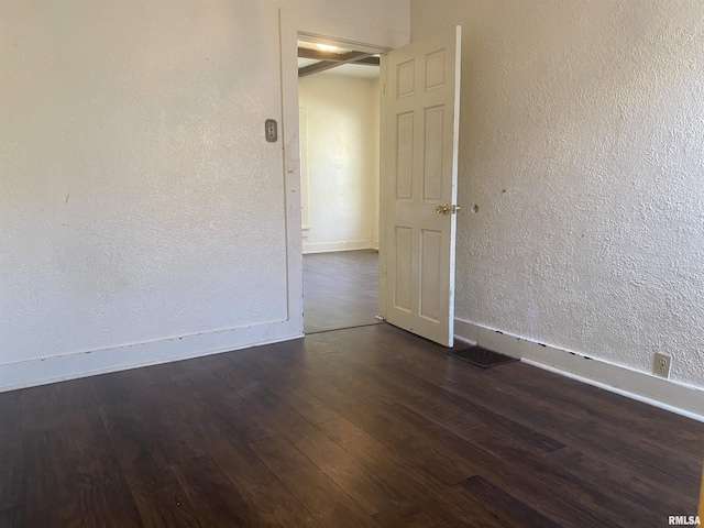 731 S Johnson St, Macomb, IL 61455 - spare room featuring dark wood-style flooring, baseboards, and a textured wall