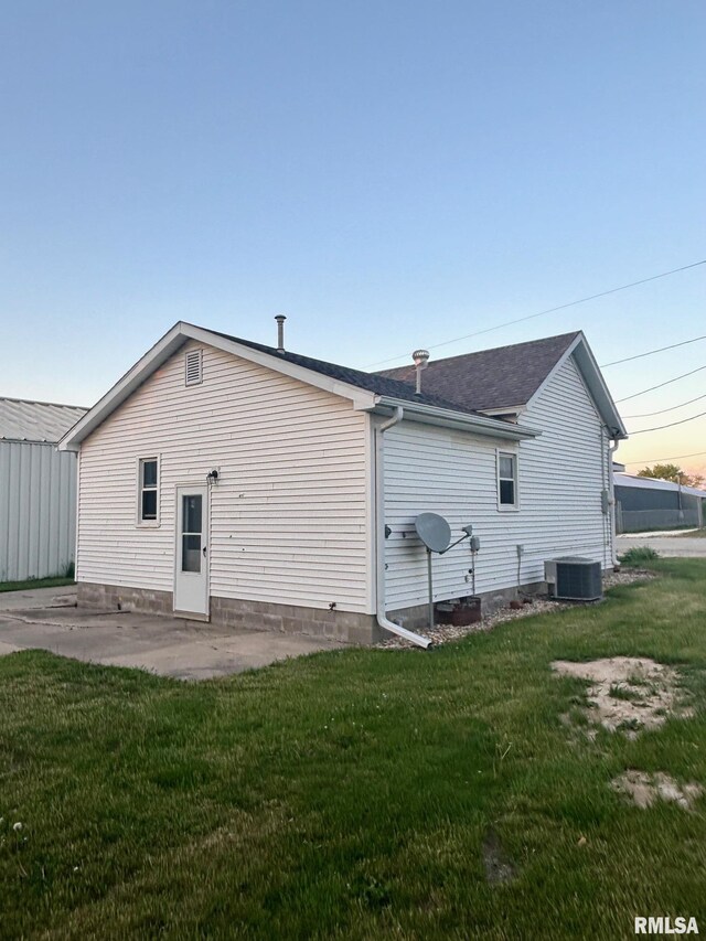 123 N Oak St, Williamsfield, IL 61489 - rear view of property featuring a lawn, a patio, central AC unit, and a shingled roof