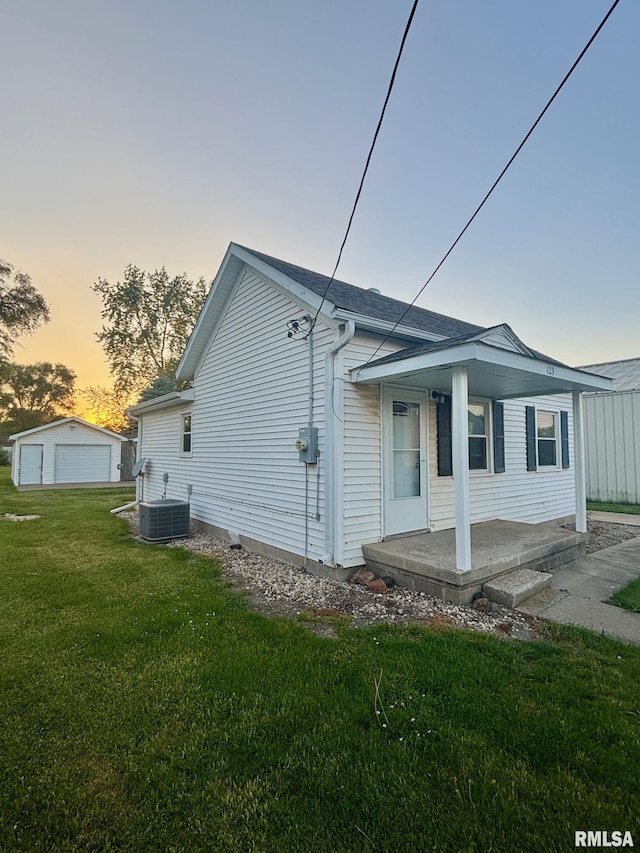 123 N Oak St, Williamsfield, IL 61489 - view of side of property with covered porch, a garage, a yard, and central AC unit