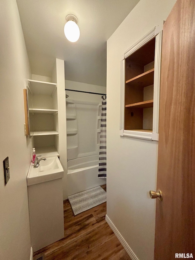 123 N Oak St, Williamsfield, IL 61489 - full bathroom with wood finished floors, a sink, shower / tub combo with curtain, and baseboards