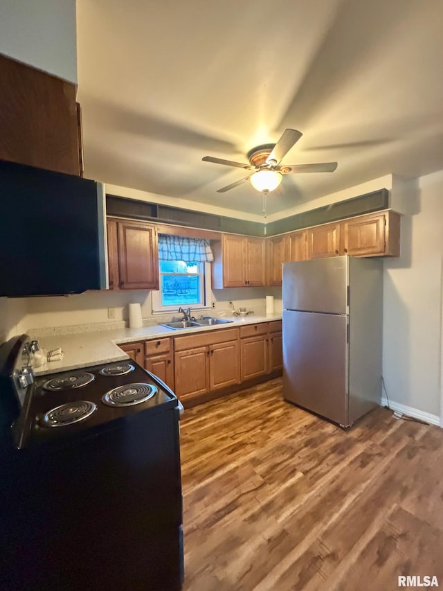 123 N Oak St, Williamsfield, IL 61489 - kitchen featuring freestanding refrigerator, black electric range oven, a sink, a ceiling fan, and wood finished floors