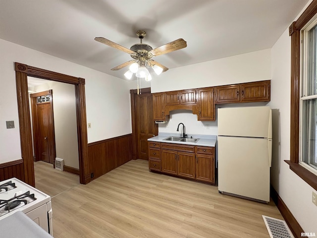 2704 N Dechman Ave, Peoria, IL 61603 - kitchen featuring white appliances, a sink, wainscoting, wooden walls, and ceiling fan