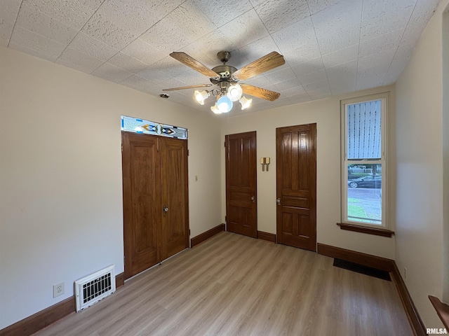 2704 N Dechman Ave, Peoria, IL 61603 - unfurnished bedroom with light wood-style flooring, baseboards, and a ceiling fan