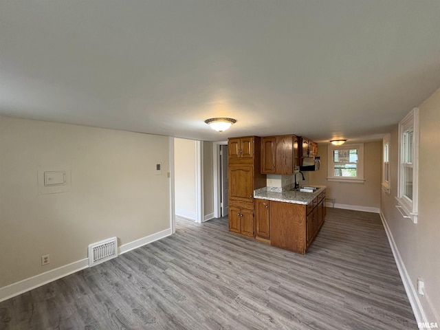 2704 N Dechman Ave, Peoria, IL 61603 - kitchen with brown cabinets, wood finished floors, a sink, and baseboards