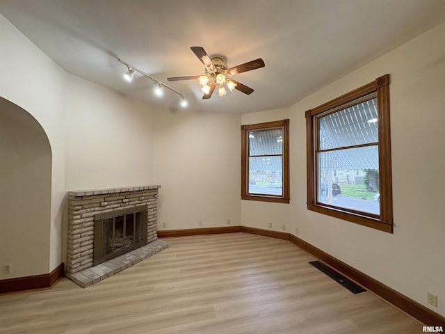 2704 N Dechman Ave, Peoria, IL 61603 - unfurnished living room featuring track lighting, a ceiling fan, light wood finished floors, and baseboards