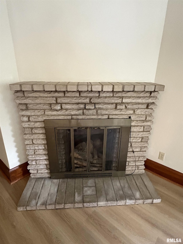 2704 N Dechman Ave, Peoria, IL 61603 - detailed view of a stone fireplace, baseboards, and wood finished floors