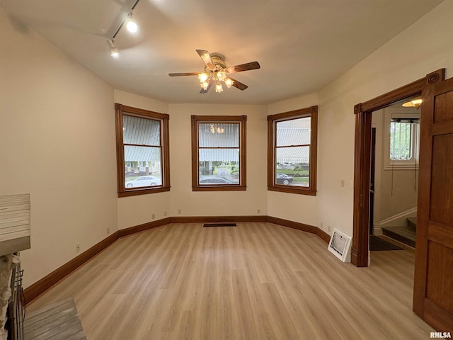 2704 N Dechman Ave, Peoria, IL 61603 - empty room featuring track lighting, light wood-type flooring, ceiling fan, and baseboards