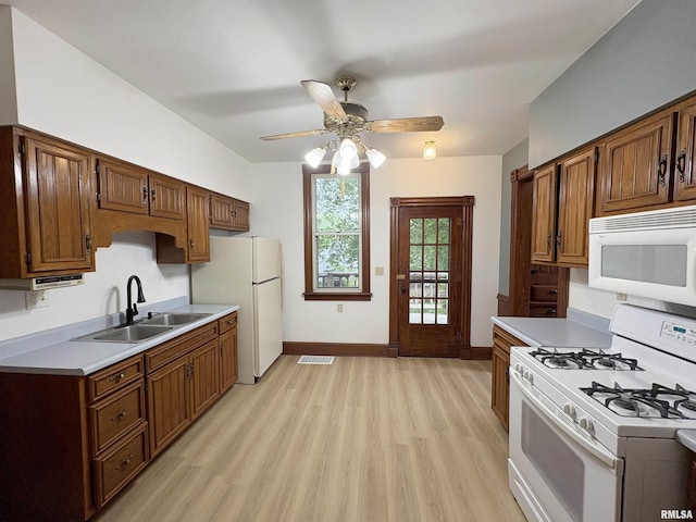 2704 N Dechman Ave, Peoria, IL 61603 - kitchen with white appliances, a sink, light wood-style floors, and light countertops