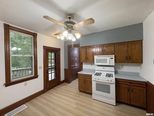 2704 N Dechman Ave, Peoria, IL 61603 - kitchen featuring white appliances, light wood-style floors, light countertops, brown cabinets, and a ceiling fan
