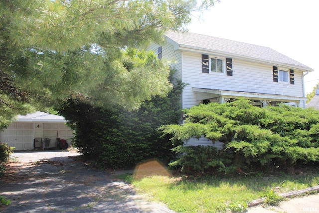 153 S Apple St, Farmington, IL 61531 - obstructed view of property featuring a garage, a shingled roof, and driveway