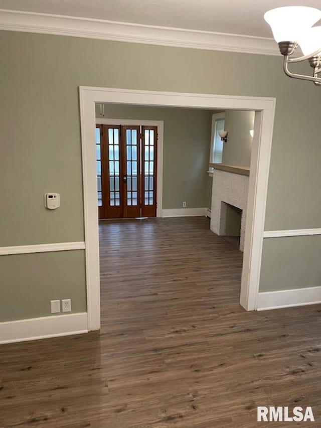 2405 N Sheridan Rd, Peoria, IL 61604 - unfurnished living room with crown molding, baseboards, a chandelier, dark wood-type flooring, and french doors