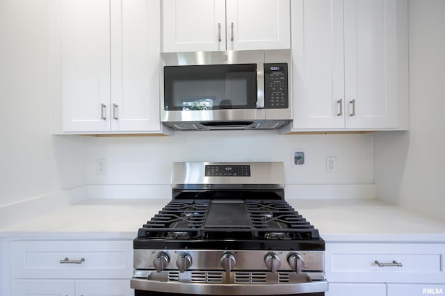 kitchen with stainless steel appliances, white cabinets, and light countertops