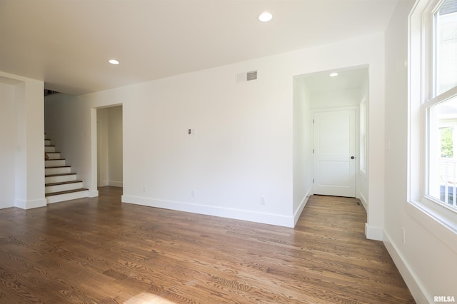 unfurnished room featuring wood finished floors, stairs, baseboards, and recessed lighting