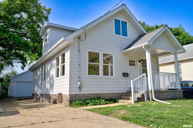 bungalow-style house featuring an outbuilding, a garage, and a front lawn