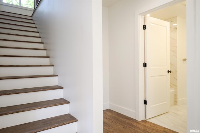 stairway with baseboards and wood finished floors