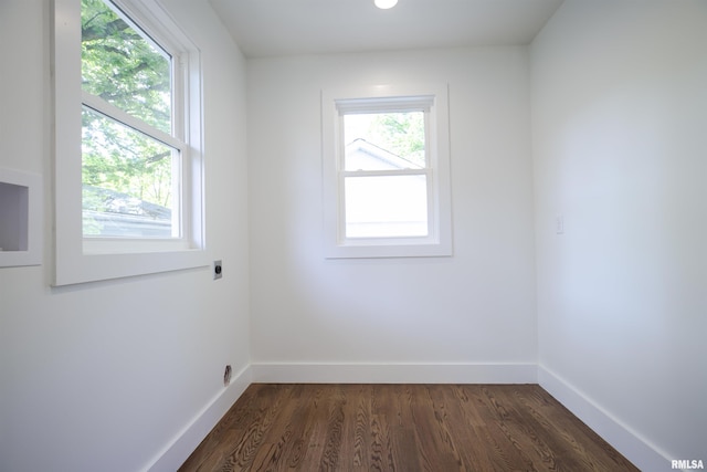 empty room featuring dark wood finished floors and baseboards