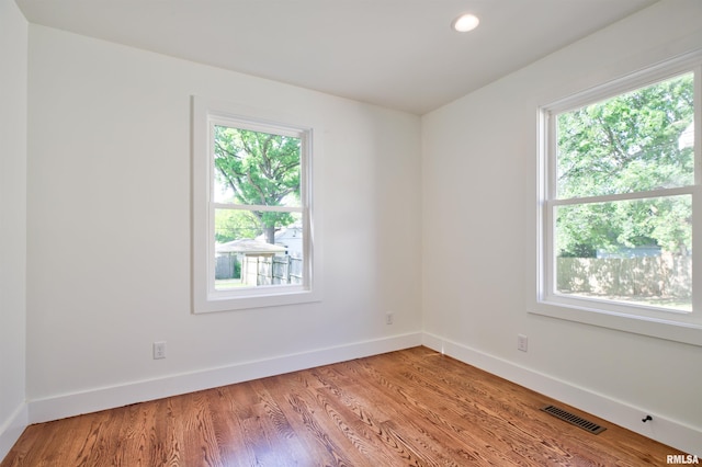 spare room featuring healthy amount of natural light, baseboards, light wood-type flooring, and recessed lighting