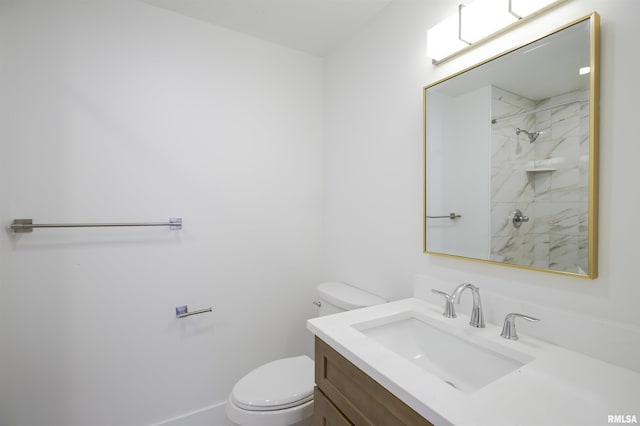 bathroom featuring toilet, vanity, and a shower
