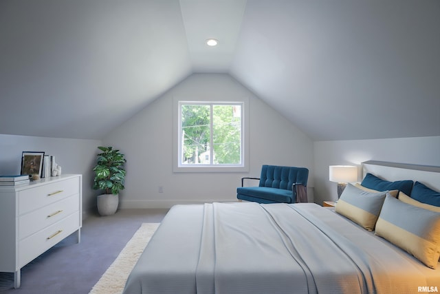 carpeted bedroom with vaulted ceiling and baseboards