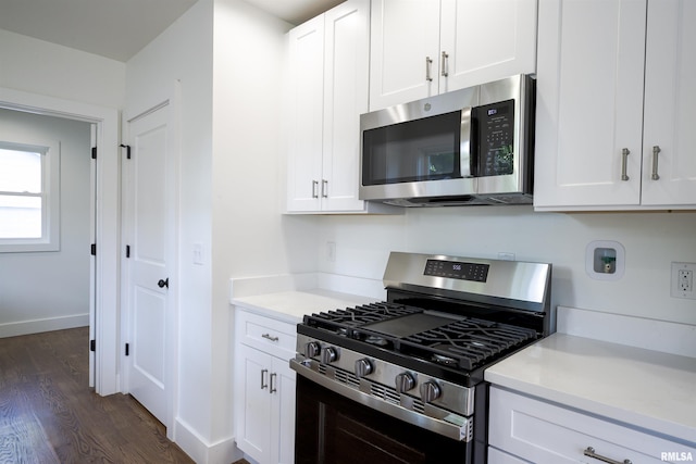kitchen featuring stainless steel appliances, dark wood-style floors, light countertops, and white cabinetry