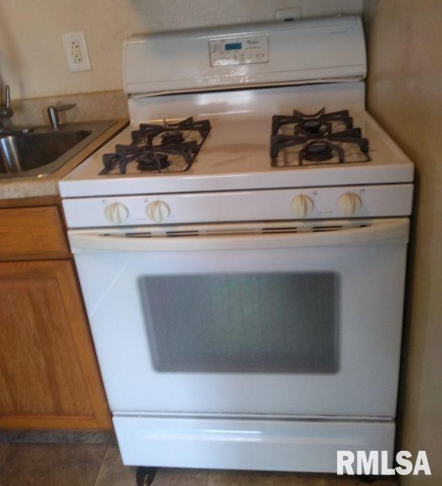 129 Pierson St, East Peoria, IL 61611 - kitchen with gas range gas stove, brown cabinets, a sink, and light countertops