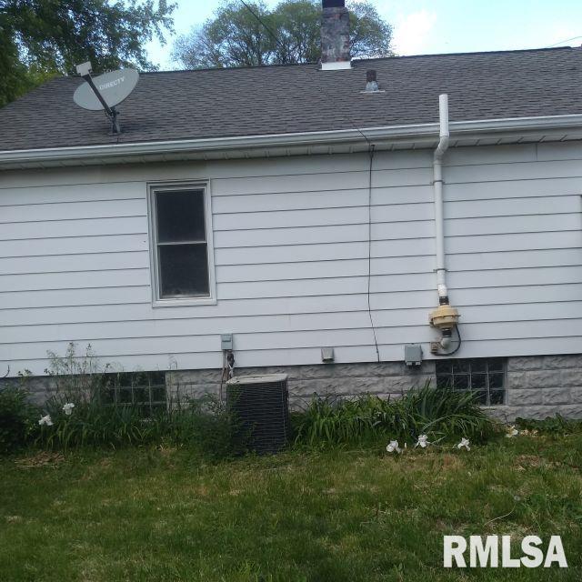 129 Pierson St, East Peoria, IL 61611 - view of side of property featuring cooling unit, a chimney, and a shingled roof