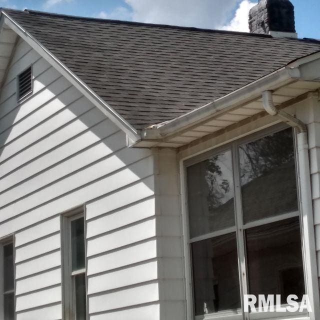 129 Pierson St, East Peoria, IL 61611 - exterior view of a downspout, gutters, roof with shingles, and a chimney