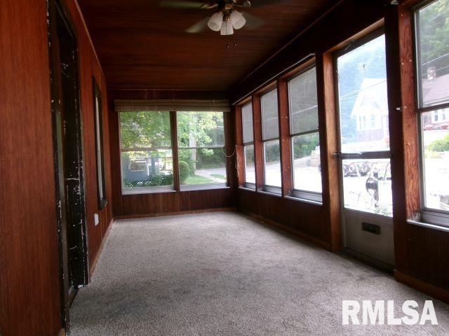 129 Pierson St, East Peoria, IL 61611 - unfurnished sunroom with healthy amount of natural light, wooden ceiling, wooden walls, and carpet