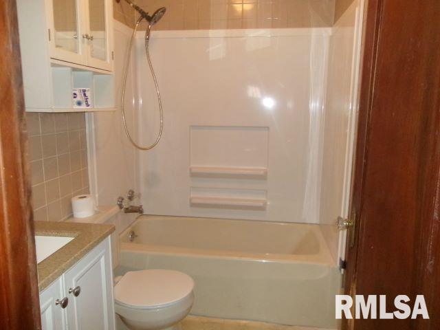 129 Pierson St, East Peoria, IL 61611 - bathroom featuring vanity, washtub / shower combination, toilet, and tile walls