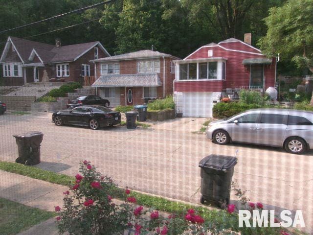 129 Pierson St, East Peoria, IL 61611 - view of front of home featuring driveway, a chimney, and an attached garage