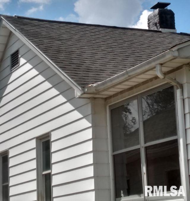 129 Pierson St, East Peoria, IL 61611 - exterior view of gutters, a downspout, a shingled roof, and a chimney