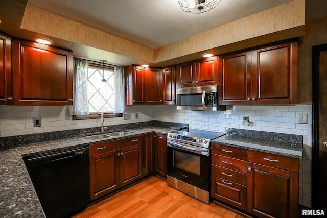 1529 W Richmar Rd, Peoria, IL 61615 - kitchen featuring stainless steel appliances, a sink, light wood-type flooring, tasteful backsplash, and dark stone counters